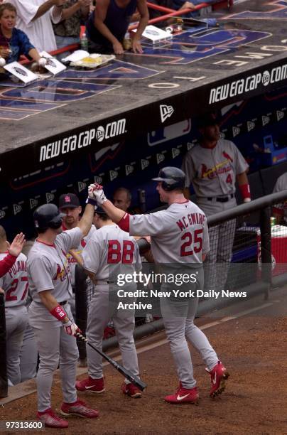 St. Louis Cardinals' Mark McGwire is congratulated in Cardinals' dugout after hitting a two-run homer in the fifth at Shea Stadium. It was McGwire's...