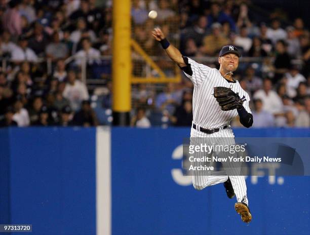New York Yankees' shortstop Derek Jeter makes a leaping throw to first in the sixth inning of a game against the Atlanta Braves at Yankee Stadium....