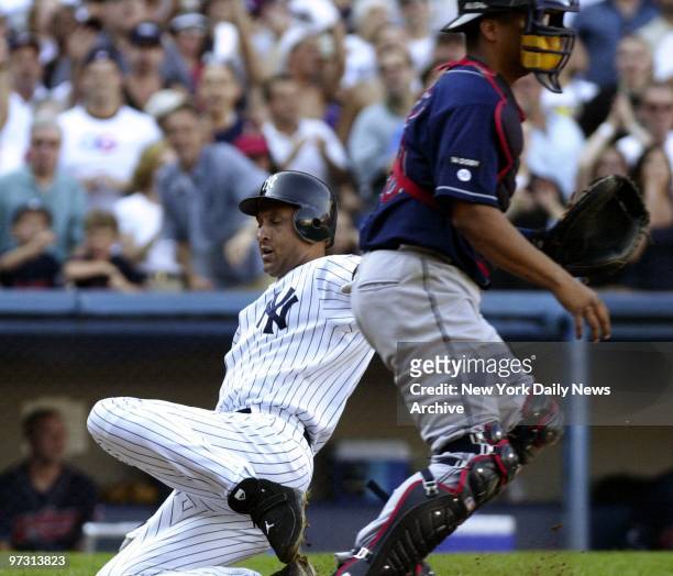 New York Yankees' shortstop Derek Jeter slides home past Cleveland Indians' catcher Victor Martinez on teammate Jason Giambi's three-run single to...