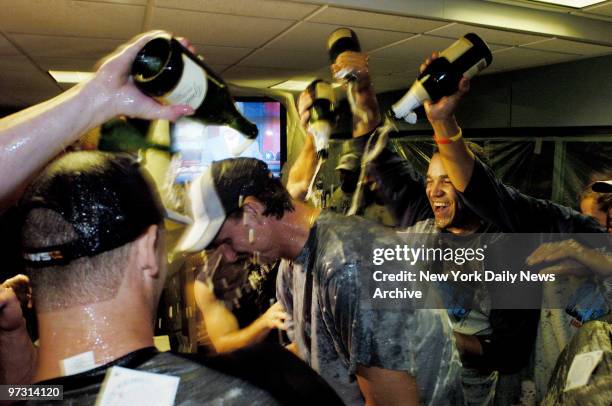 New York Yankees shower pitcher Randy Johnson with champagne in the clubhouse at Fenway Park after the Yanks beat the Boston Red Sox, 8-4, to win...