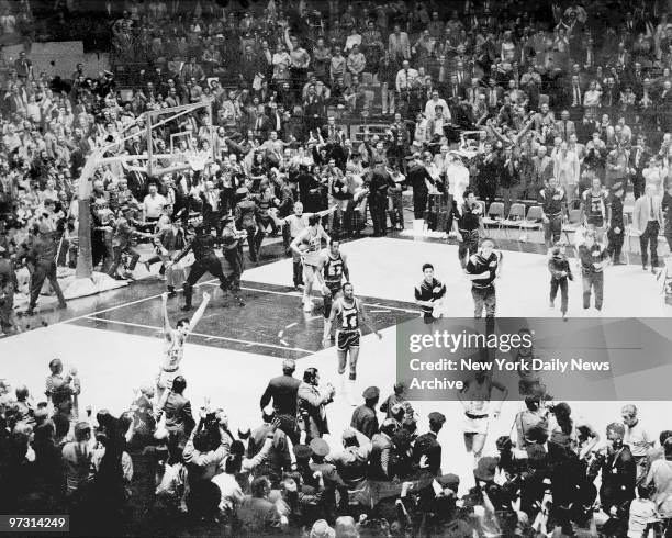 New York Knicks and fans go wild on the court at Madison Square Garden after the team defeated the Los Angeles Lakers to win the NBA Championship.