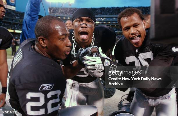 Oakland Raiders' Terrance Shaw, Tim Johnson and Clarence Love celebrate after beating the New York Jets, 30-10, in the AFC divisional playoff game at...