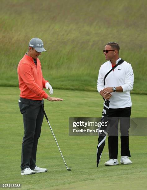 Justin Rose of England talks with golf instructor Sean Foley during a practice round prior to the 2018 U.S. Open at Shinnecock Hills Golf Club on...