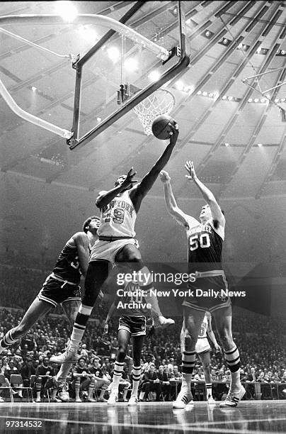 New York Knicks' captain Willis Reed gets away from the Milwaukee Bucks' Lew Alcindor and Len Chappell to make a spinning layup.