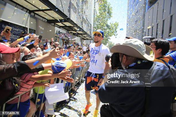 Stephen Curry of the Golden State Warriors high five fans during the Victory Parade on June 12, 2018 in Oakland, California. The Golden State...