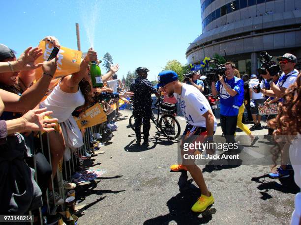 Stephen Curry of the Golden State Warriors celebrates with fans during the Victory Parade on June 12, 2018 in Oakland, California. The Golden State...