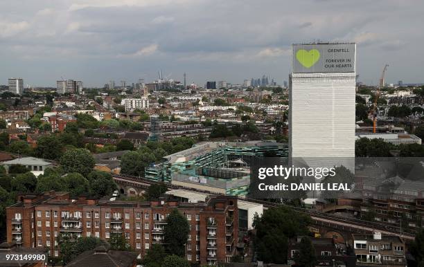 Hoardings in support of the victims of the Grenfell fire cover Grenfell Tower near Ladbroke Grove, west London on June 13, 2018. - Commemorations...