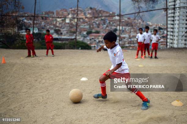 Venezuelan boy attends football classes at the San Jose de Calasanz School in Catia neighborhood in Caracas on June 11, 2018. - In Catia -birthplace...