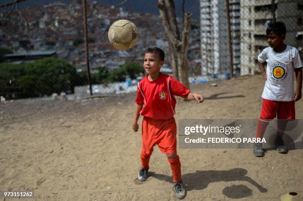 Venezuelan boy attends football classes at the San Jose de Calasanz School in Catia neighborhood in Caracas on June 11, 2018. - In Catia -birthplace...