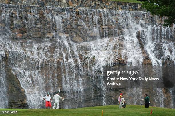 Golfers play the 13th hole against a backdrop of waterfalls during opening celebration for the Trump National Golf Club in Briarcliff Manor, N.Y.