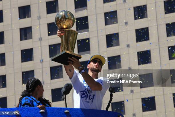 Stephen Curry of the Golden State Warriors holds up the Larry O'Brien Championship Trophy during the Golden State Warriors Victory Parade on June 12,...