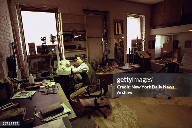 Juan Salazar, a squatter and an artist from the lower East Side, working in his home.,