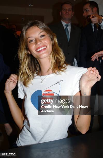 Supermodel Gisele Bundchen shows off her CFDA/Vogue "Fashion for America" T-shirt while autographing copies of Vogue at Bergdorf Goodman. Proceeds...