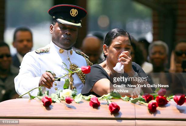 Trinidad and Tobago Cadet Corps. Maj. Lawrence Wilson, wearing his dress whites, and Simona Francis lay roses on the casket of their son, Pfc. Le Ron...