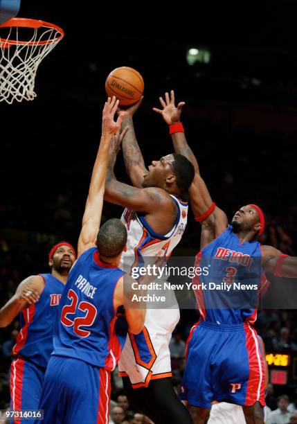 New York Knicks' Eddy Curry shoots over Detroit Pistons' Tayshaun Prince and Ben Wallace, but was then called for traveling during a game at Madison...