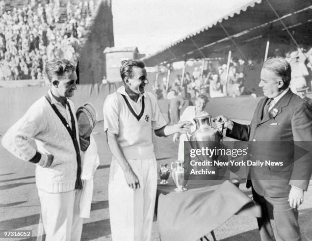 Trophy is presented to Fred Perry by Holcombe Ward after he won the National Singles Tennis Championship. Looking on is Jack Crawford.