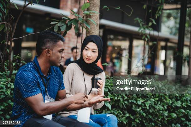 young adult couple taking a break from business during an event - employee badge stock pictures, royalty-free photos & images