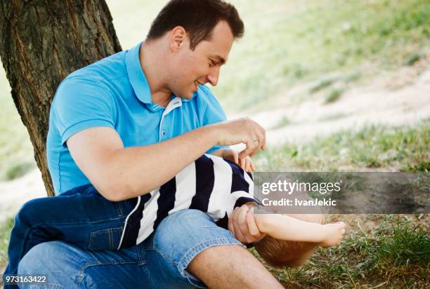 father tickling his son in nature - ivan jekic stock pictures, royalty-free photos & images