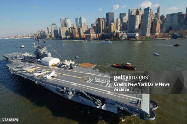 Tug boats guide the USS Intrepid down the Hudson River to Bayonne, N.J., where it will undergo a two-year, $60 million renovation. The historic...