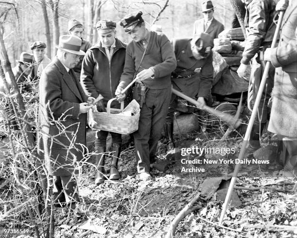 Medical Examiner Dr. Amos O. Squire holds bones of the slain Grace Budd after ghastly relics were dug up by cops in abandoned house in Westchester...