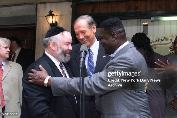 Gov. George Pataki looks on as Norman Rosenbaum and Carmel Cato exchange greetings at a news conference on E. 34th St., on the 11th anniversary of...