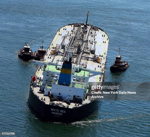 Tugboats straddle the oil tanker White Sea as it sits grounded off Coney Island. The tanker, carrying more than 19 million gallons of fuel oil, ran...