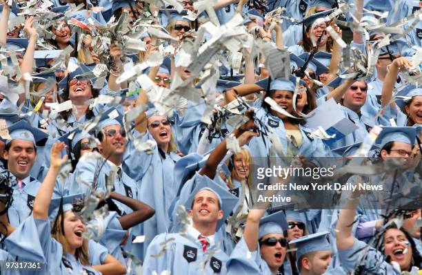 Journalism graduates toss shredded newspapers in celebration during Columbia University's 252nd commencement ceremony at the Morningside campus.