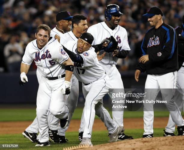Joyous New York Mets mob grinning third baseman David Wright after Wright hit an RBI walkoff single off New York Yankees' closer Mariano Rivera in...