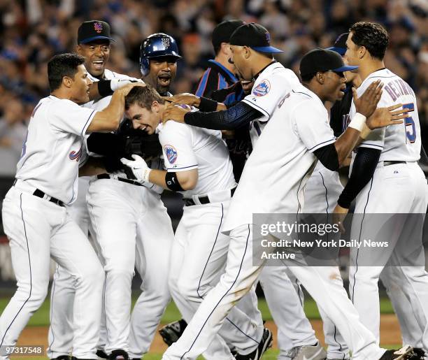 Joyous New York Mets mob third baseman David Wright after Wright hit an RBI walkoff single off New York Yankees' closer Mariano Rivera in the bottom...