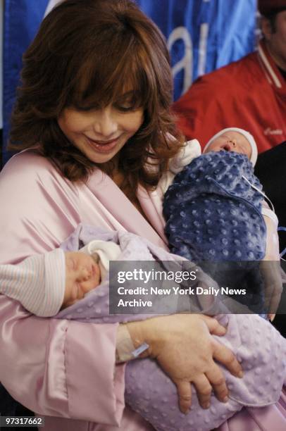 Twins Francesca and Gian snooze through their first news conference in the arms of their smiling mother, Aleta St. James, on the day after the babies...