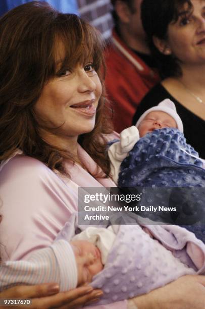 Twins Francesca and Gian snooze through their first news conference in the arms of their smiling mother, Aleta St. James, on the day after the babies...