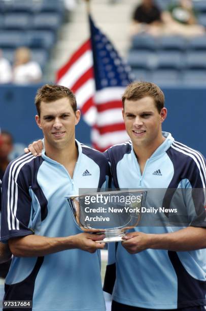 Twins Mike and Bob Bryan of the United States hold their first-place trophy after defeating Jonas Bjorkman of Sweden and Max Mirnyi of Belarus in the...