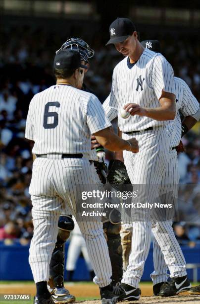 New York Yankees' starter Randy Johnson hands the ball over to manager Joe Torre as he's removed after giving up nine runs and six hits to the Tampa...