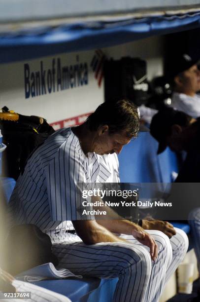 New York Yankees' starter Randy Johnson hangs his head in the dugout after being pulled from the game near the end of the sixth inning against the...