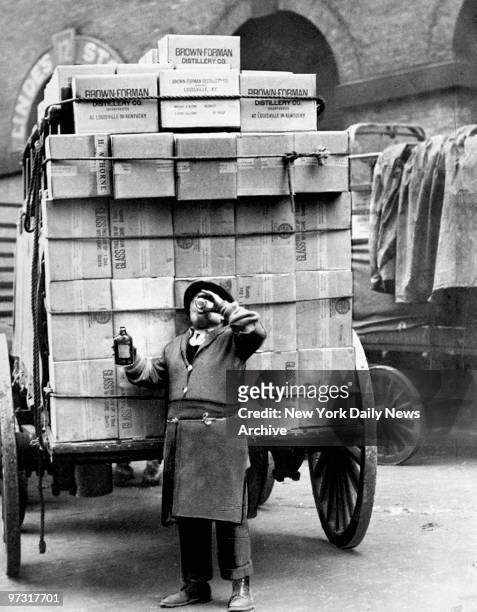 Delivering legal liquor the day after repeal of prohibition. Driver Tony Pasquale takes a drink of Kentucky whiskey at Beach and Varick Streets, New...
