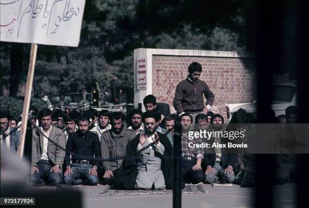 Taken through the locked gates of the US embassy in Tehran, a mullah leads Iranian students in afternoon prayer a month into the Iran Hostage Crisis,...