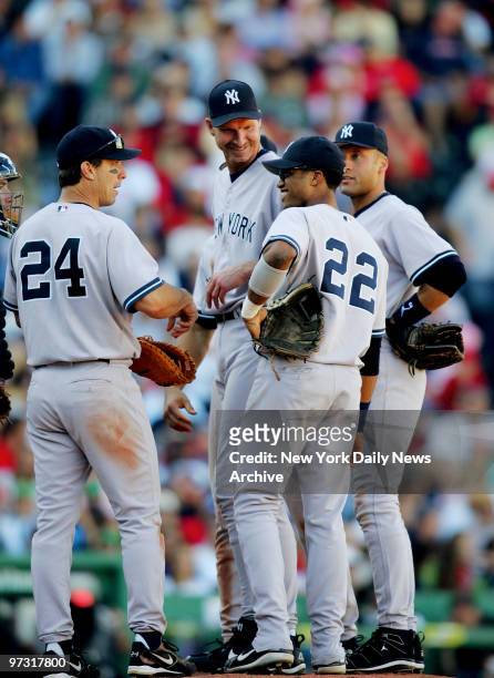 New York Yankees' starter Randy Johnson, who's surrounded by Tino Martinez, Robinson Cano and Derek Jeter , smiles as he waits to be relieved in the...