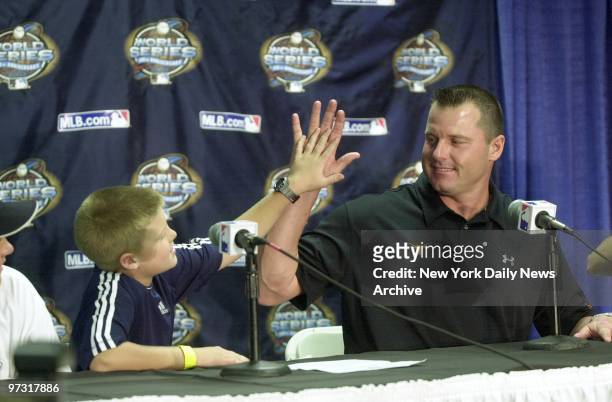 New York Yankees' starter Roger Clemens gets a high five from his son during a news conference after Game 4 of the World Series at Pro Player...