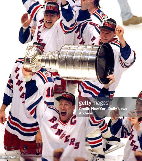 Jubilant New York Rangers' captain Mark Messier hoists the Stanley Cup over his head in celebration of the Rangers defeating the Vancouver Canucks...