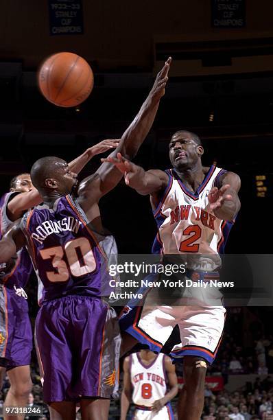 New York Knicks' Larry Johnson passes around Phoenix Suns' Clifford Robinson. Phoenix won, 88-84, in overtime at Madison Square Garden.