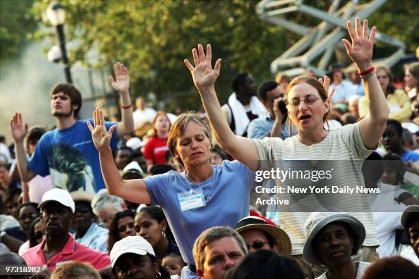 Members of the audience pray before the Rev. Billy Graham speaks on the second day of the Greater New York Billy Graham Crusade at Flushing...