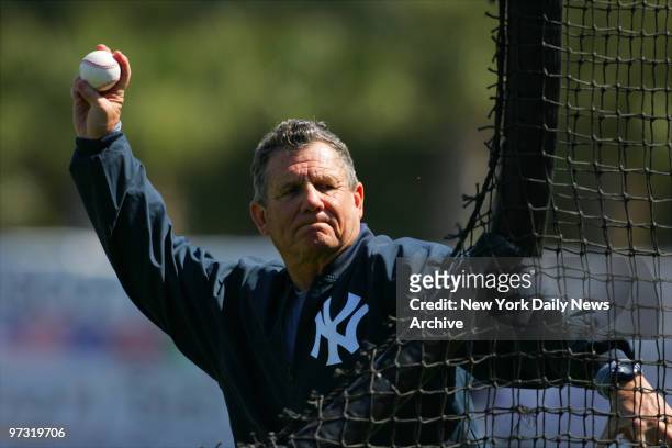New York Yankees' third base coach Larry Bowa throws batting practice pitches from behind a screen during spring training at Legends Field.