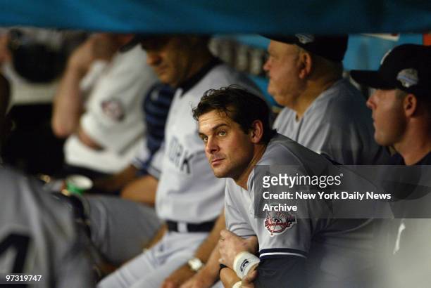 New York Yankees' third baseman Aaron Boone, with manager Joe Torre and bench coach Don Zimmer in the background, watches glumly from the dugout as...