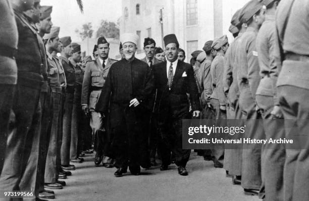 Haj Amin al-Husseini. The Grand Mufti of Jerusalem and head of the Arab Higher Committee. Reviewing a guard of honorat a village in Galilee on 23...