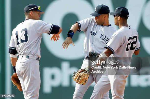 New York Yankees' third baseman Alex Rodriguez, shortstop Derek Jeter and second baseman Robinson Cano celebrate on the field after defeating the...