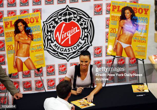Olympic gold medal swimmer Amanda Beard signs copies of the July issue of Playboy magazine, in which she posed for a nude layout, at the Virgin...