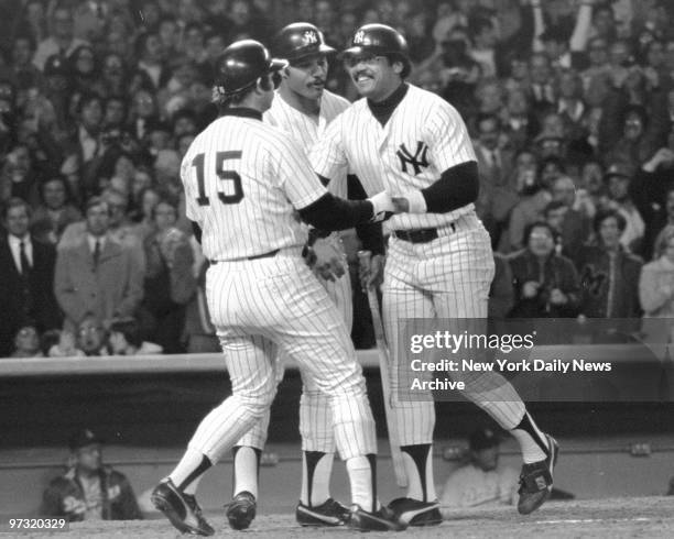 New York Yankees' Thurman Munson and Chris Chambliss lead welcoming committee in the fourth inning for Reggie Jackson after his first of three home...