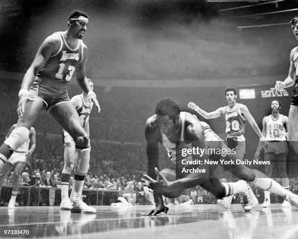 New York Knicks' MVP center Willis Reed falls heavily to the floor while dribbling downcourt near the Los Angeles Lakers basket in the first quarter...