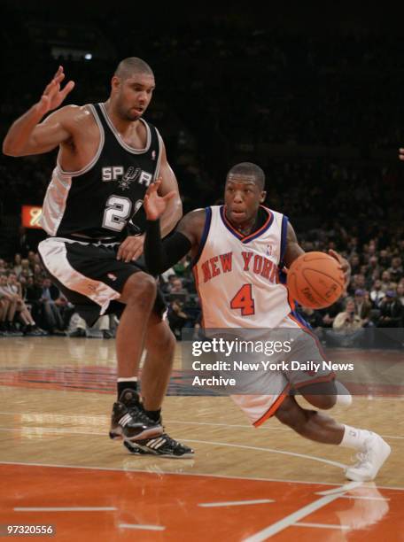 New York Knicks' Nate Robinson drives to the basket around San Antonio Spurs' Tim Duncan during a game at Madison Square Garden. The Knicks went on...