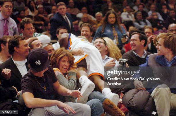 New York Knicks' Nate Robinson gets intimate with fans after diving into the stands while chasing the ball during a game against the Houston Rockets...